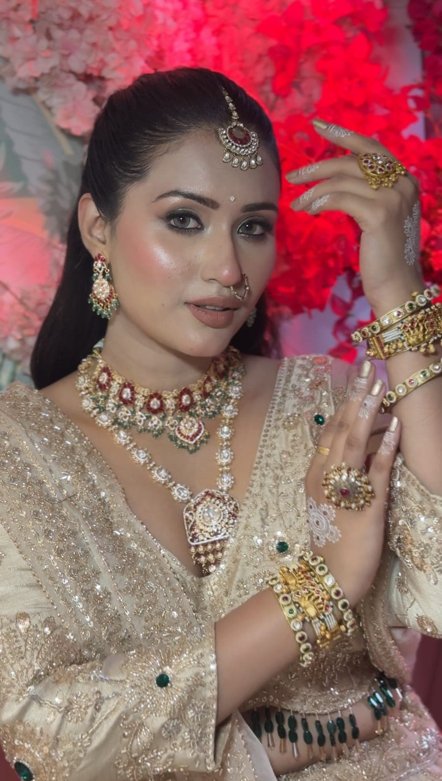 Bride in a pale embellished outfit with a maang tikka and layered jewellery
