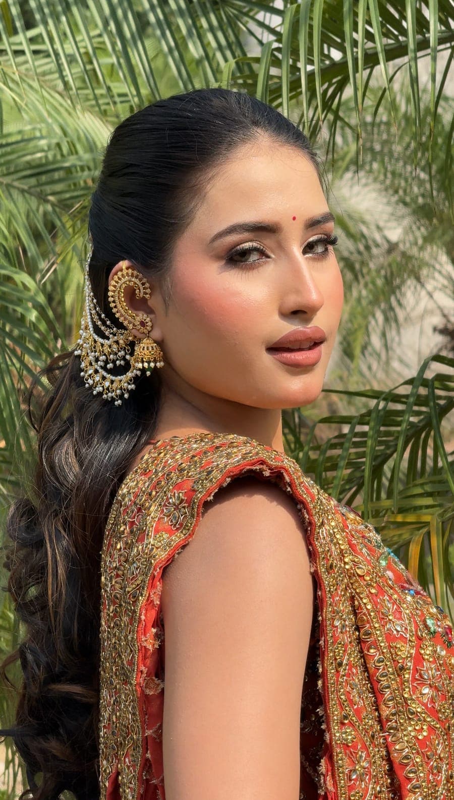 Bridal portrait outdoors with softly styled hair and gold earrings