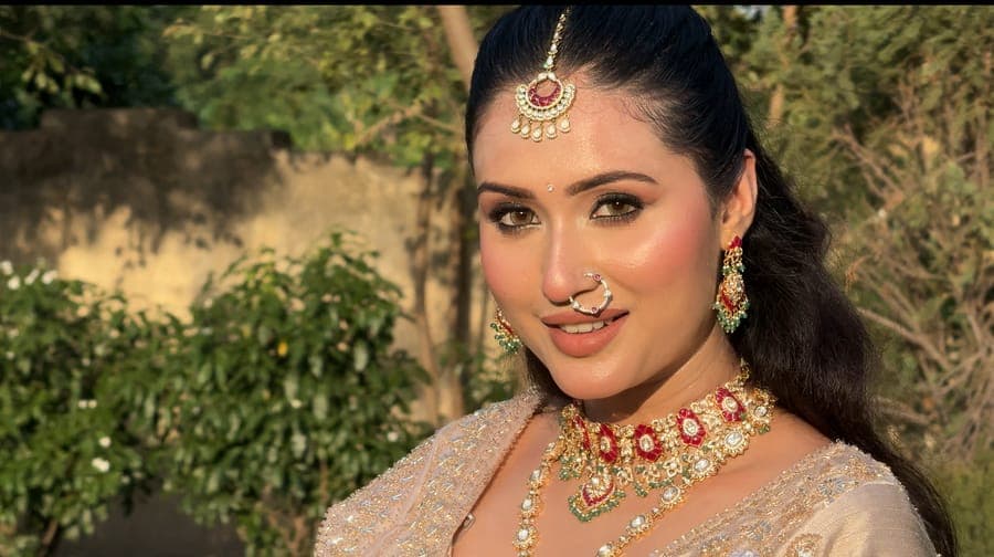 Bride outdoors wearing traditional jewellery in warm sunlight